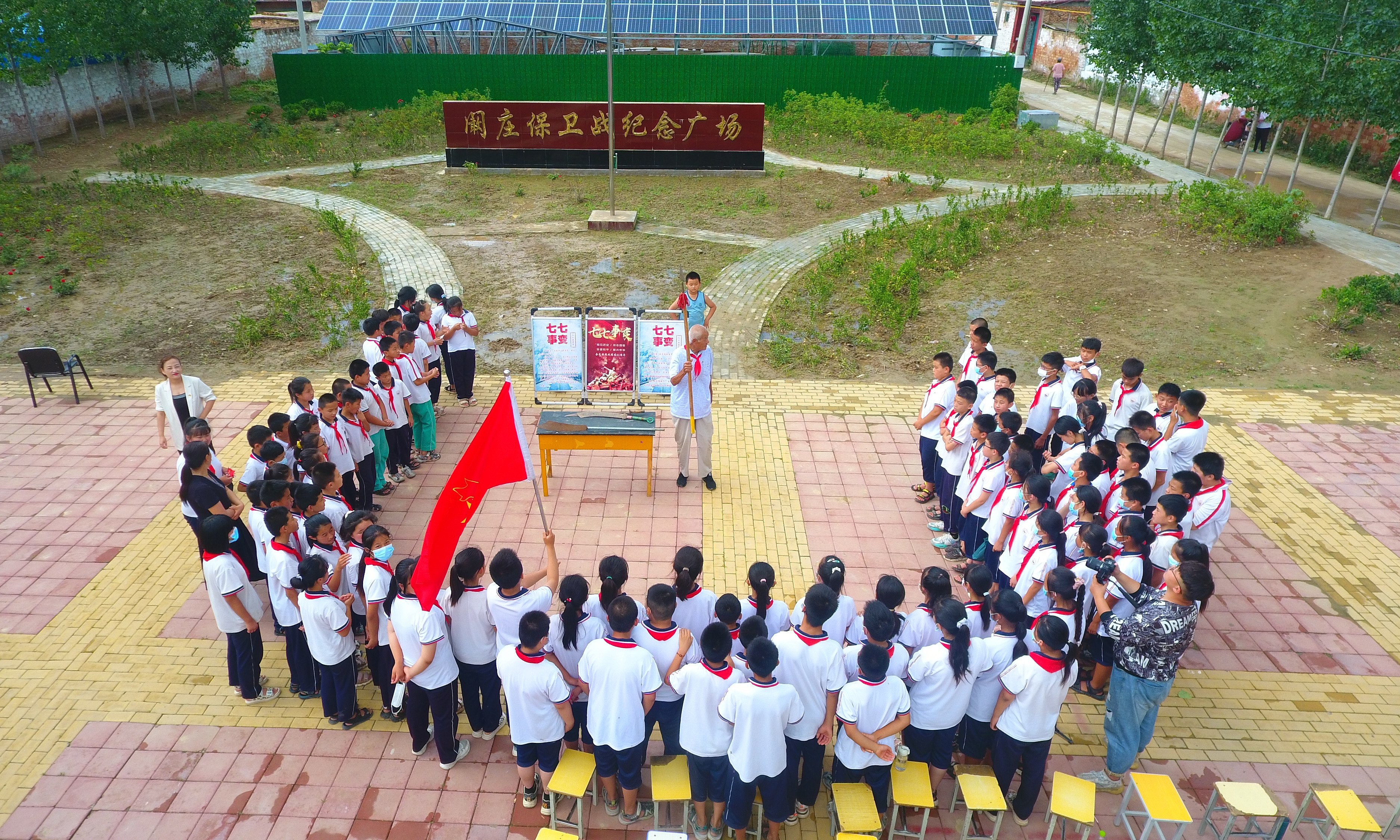 2022年7月6日，山東省聊城市，在茌平區(qū)菜屯鎮(zhèn)闞莊村的闞莊保衛(wèi)戰(zhàn)紀(jì)念廣場(chǎng)，闞莊保衛(wèi)戰(zhàn)親歷者王光木老人，為小學(xué)生們講述抗戰(zhàn)故事，展示大刀、長矛。